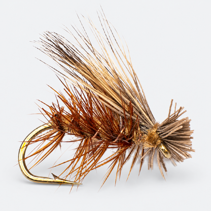 Tan Elk Hair Caddis single fly on a pale gray background