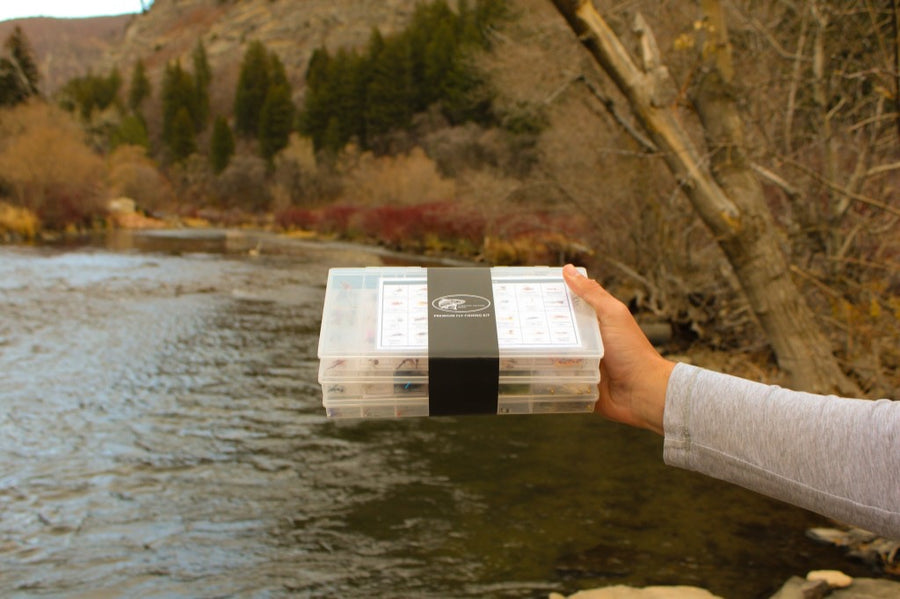 Premium fly fishing kits held over the river